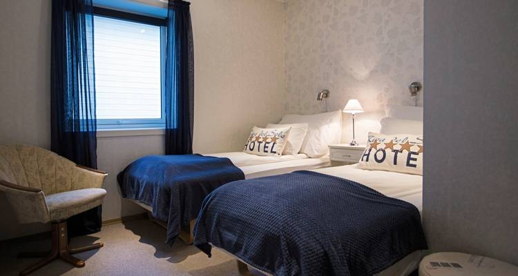 Chambre d'hôtel avec lits jumeaux et décoration simple.