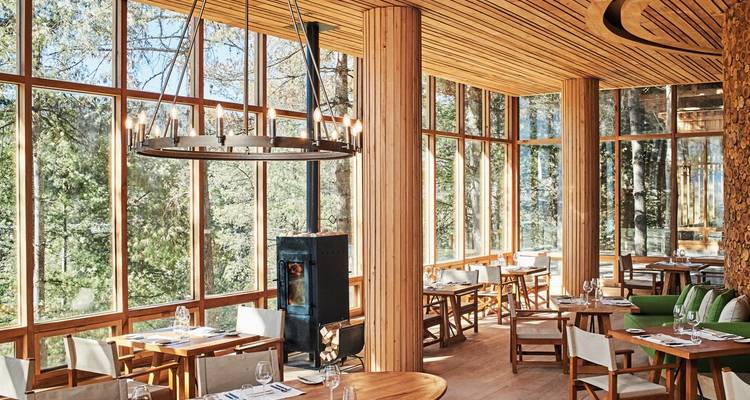 Elegantes Restaurant mit großen Fenstern und hölzener Innenausstattung.