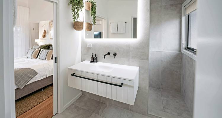 Un intérieur de salle de bain moderne avec des équipements élégants et une vue sur une chambre.
