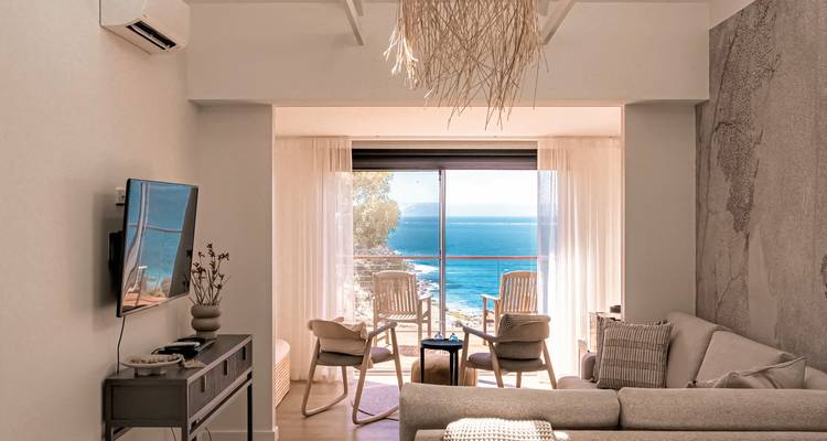 Un salon confortable avec vue sur l'océan à travers de grandes fenêtres.