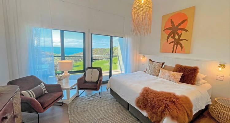 Une chambre avec vue sur la mer, décorée dans des tons chauds.