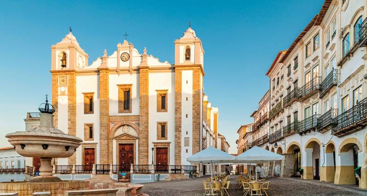 Stadtplatz mit einem historischen Gebäude und einem Brunnen.