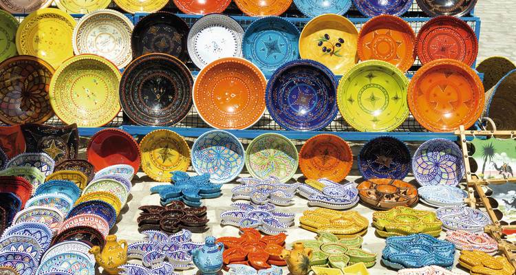 Colorful pottery displayed outside, showcasing intricate designs.