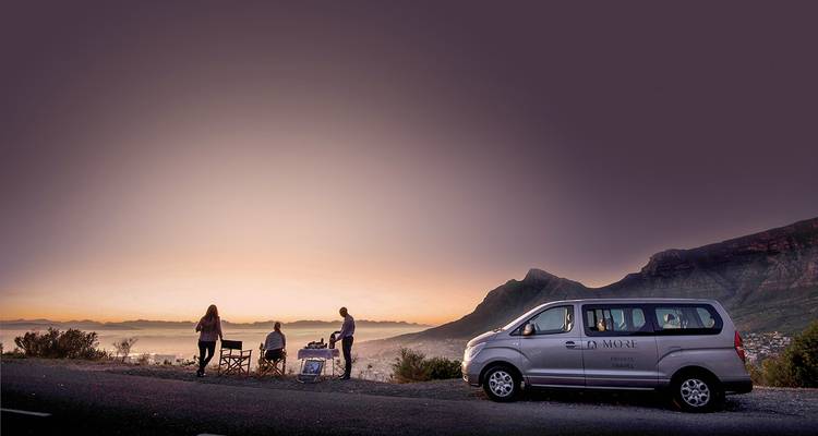Group of people enjoying a scenic view from a hillside.
