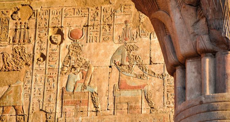 An ancient wall with intricate Egyptian carvings and hieroglyphics.
