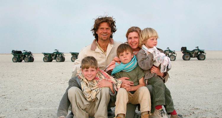 Famille posant devant des quads sur un paysage plat.
