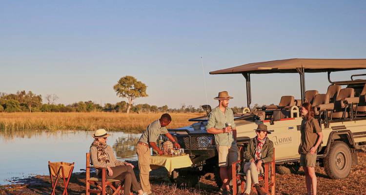 Groupe de personnes profitant d'un pique-nique safari au bord d'un plan d'eau.