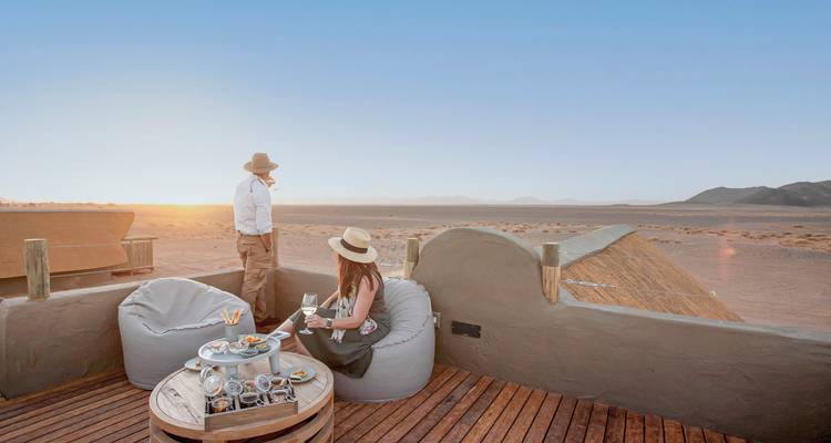 People enjoying a sunset with dunes in the foreground.
