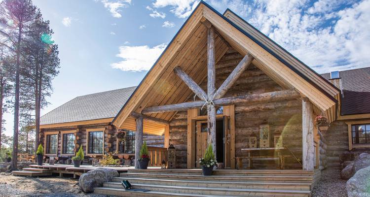 Blockhaus mit rustikaler Einrichtung unter klarem Himmel.
