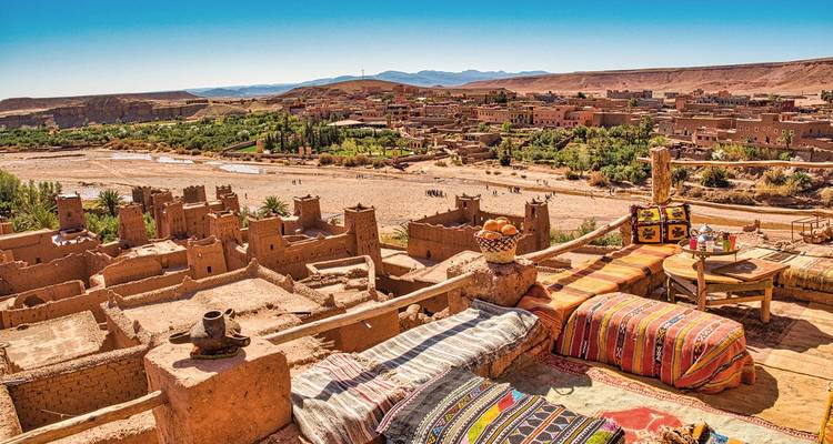 Dachterrasse mit Blick auf eine Wüstenlandschaft und farbenfroher Dekoration.