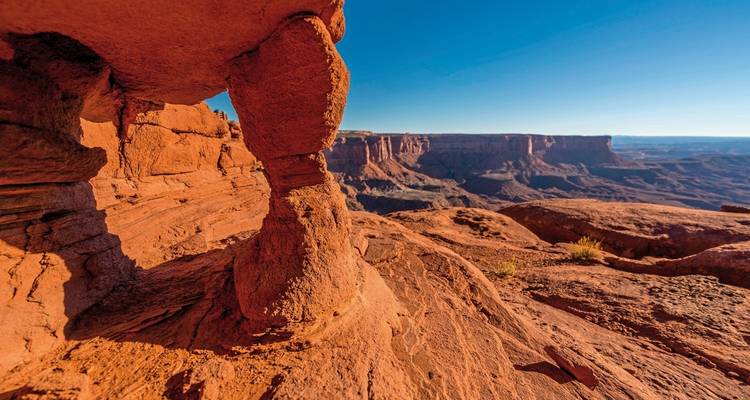 Des formations rocheuses rouges dans un paysage désertique avec une arche.