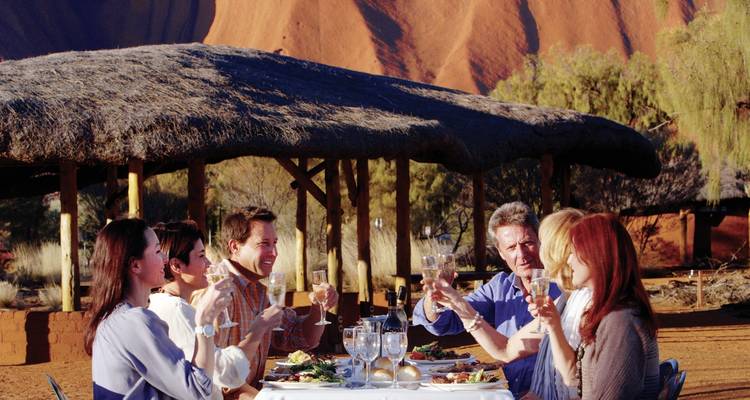 Group dining outdoors with iconic red rock background