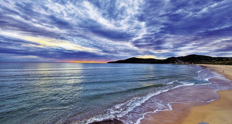 Scenic beach with gentle waves and a colorful sky