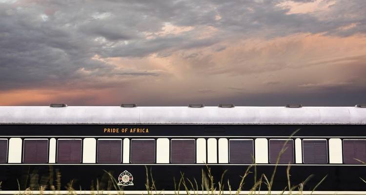 Train carriage with 'Pride of Africa' markings under a dramatic sky.