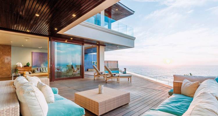 Luxurious terrace with ocean view, sofas and lounge chairs.