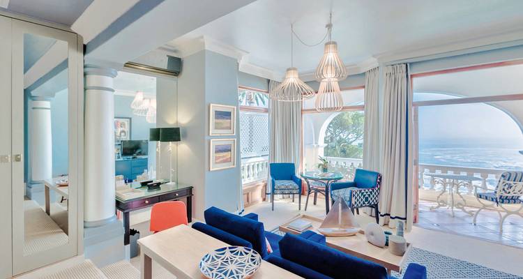 Bright hotel lounge with blue and white decor and sea view.