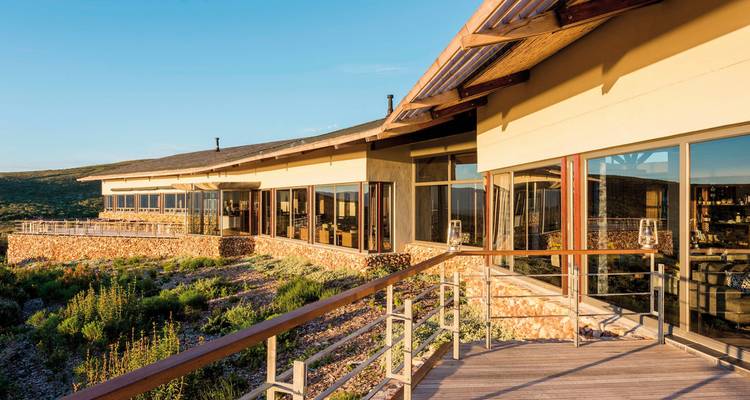 Ein Außenblick auf ein modernes Gebäude mit Glasfenstern an einem Hang.