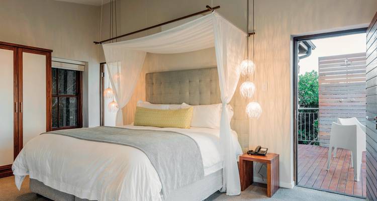 Ein modernes Schlafzimmer mit einem Himmelbett und eleganter Beleuchtung.