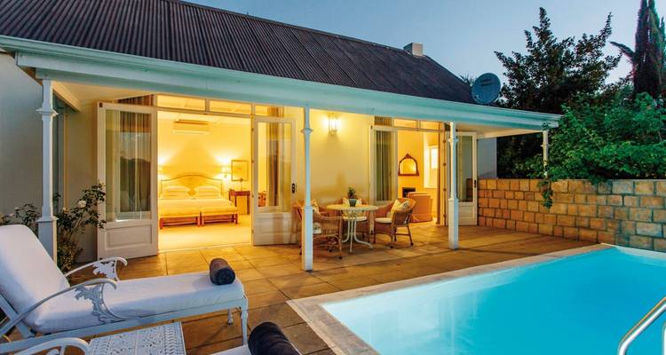 Hébergement de luxe avec espace piscine privée illuminé la nuit.