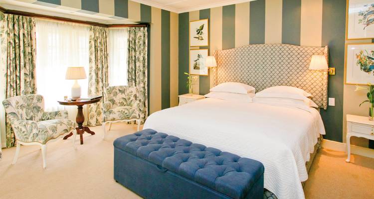 Une chambre élégante et bien éclairée avec de grandes fenêtres et une décoration florale.