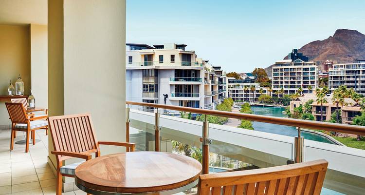 Vue du balcon donnant sur les canaux urbains avec montagnes.