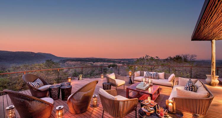 Outdoor lounge area with scenic views at sunset.