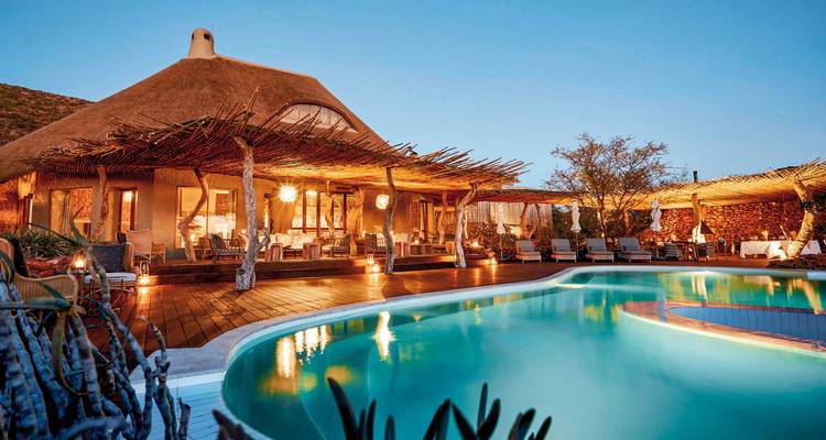 Luxury lodge with a pool at dusk.