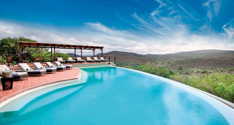 Infinity pool overlooking a landscape on a sunny day.