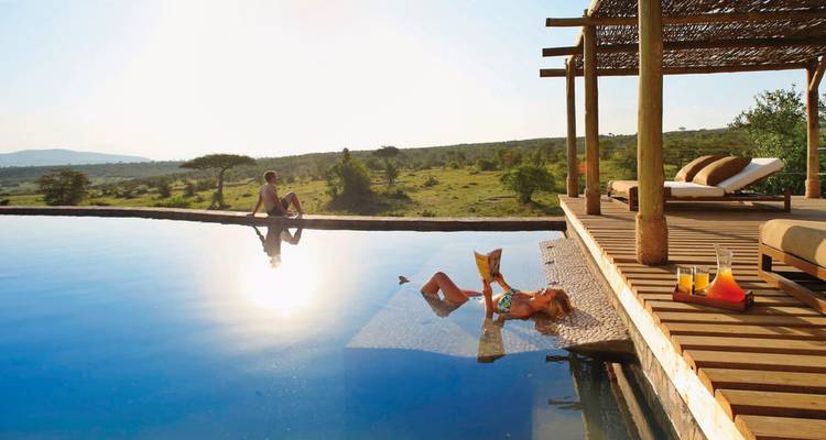 Menschen entspannen an einem Infinity-Pool mit Blick auf die Savanne.