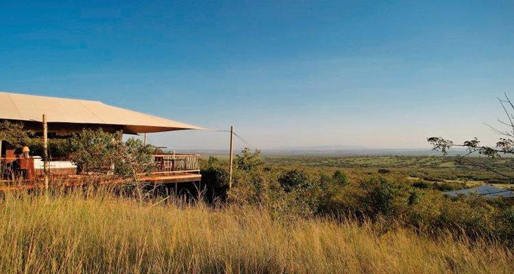 Blick aus einem Zelt über ein weites Grasland.