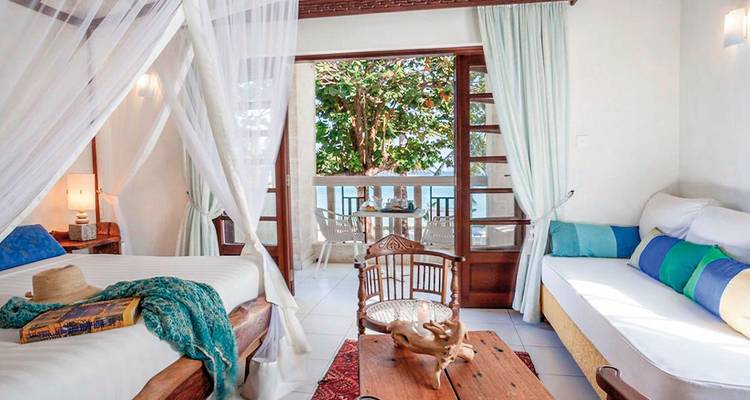 Interieur van een kamer met een balkon met uitzicht op de oceaan.