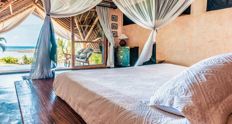 Slaapkamer met zeezicht in een tentaccommodatie.