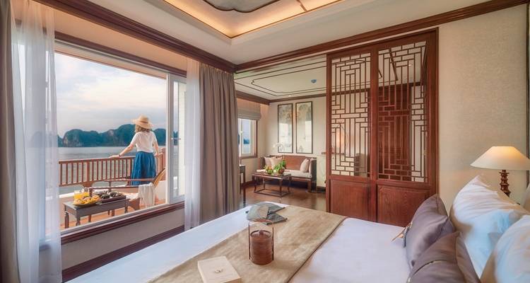 Une chambre d'hôtel confortable avec vue sur le balcon extérieur et une personne profitant de la vue.