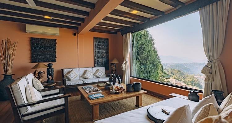 Eine gemütliche Lounge mit Sofas, einem großen Fenster und Blick auf die malerische Naturlandschaft.
