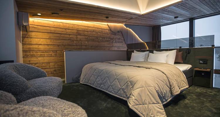 Stilvolles modernes Schlafzimmer mit gesteppter Bettwäsche und warmem indirektem Licht