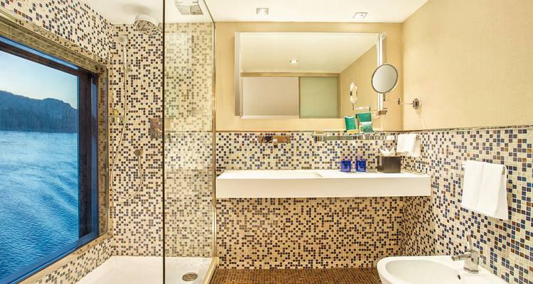 Baño lujoso con vista al agua.