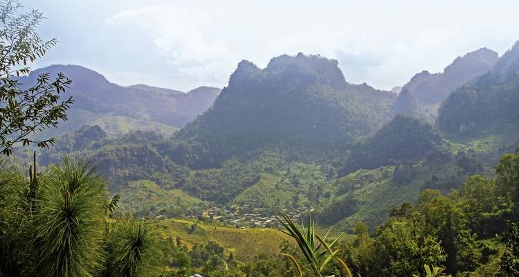 Paysage montagneux verdoyant sous un ciel dégagé.