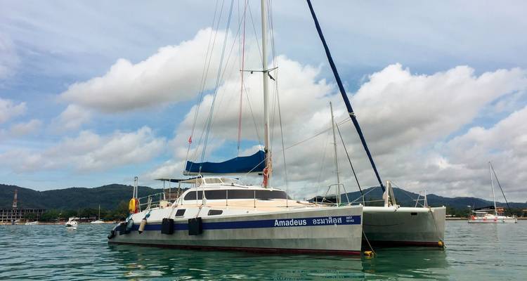 Zeilboot aangemeerd in een jachthaven met heuvels op de achtergrond.