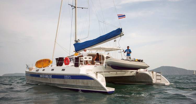 Zeilboot met mensen aan boord in open water.
