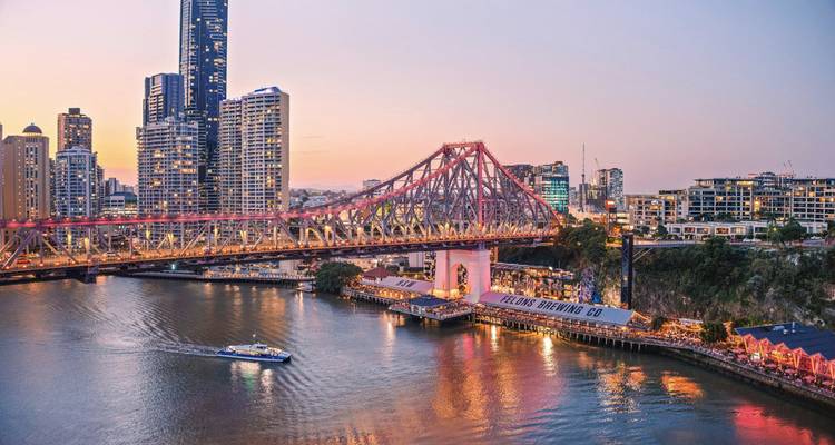 City view with a bridge over a river at sunset.