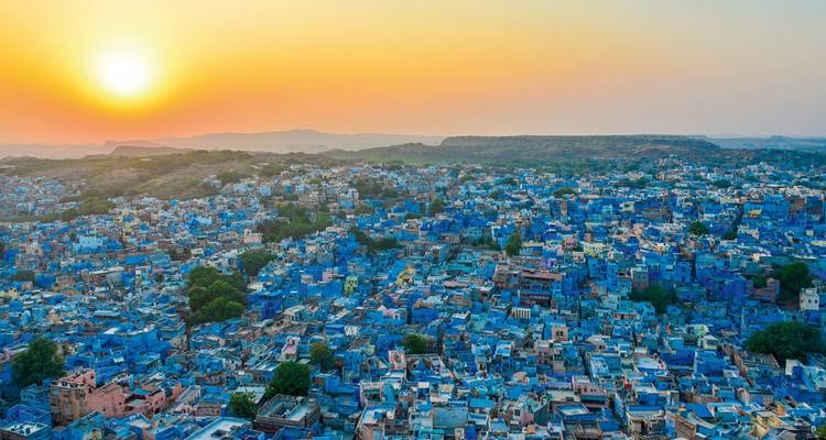 Vue aérienne d'une ville avec des maisons bleues et un coucher de soleil