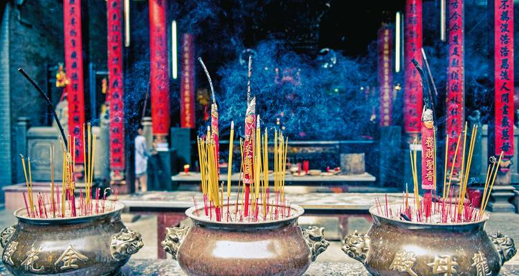 Incense sticks burning in a temple setting.
