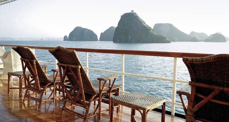 View of Halong Bay from a boat deck with chairs facing the sea.