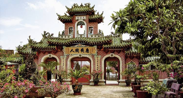 Entrance gate of an ornate temple surrounded by lush greenery.