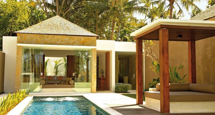 Villa de lujo con piscina rodeada de plantas tropicales.