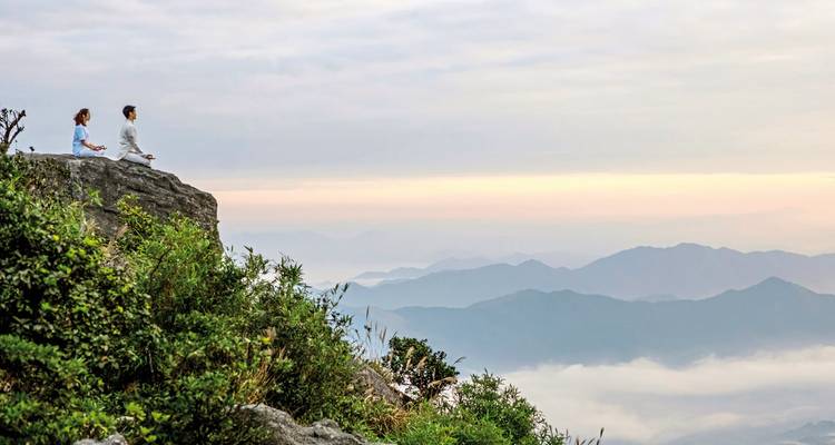 Couple meditating with view of rolling hills