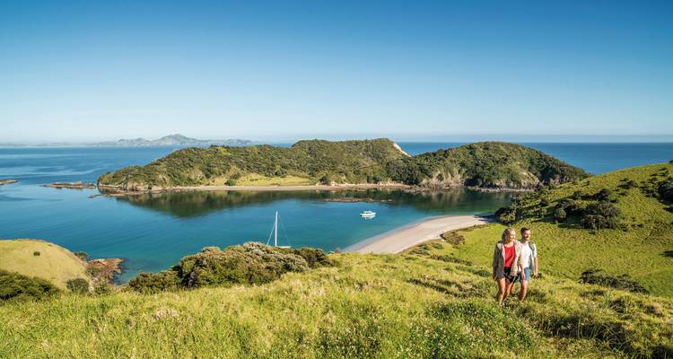 Couple hiking with a view of a bay in New Zealand.