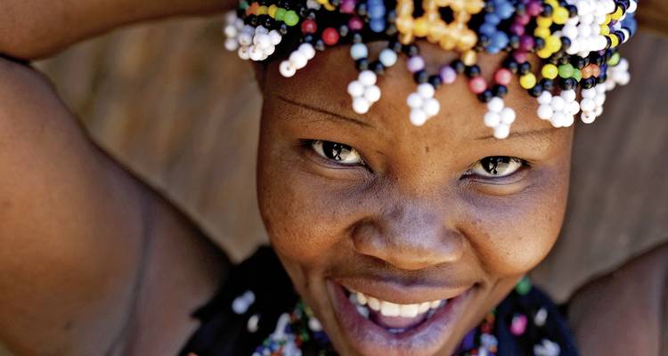 Portrait d'une femme souriante portant des perles.