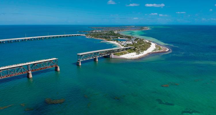 Vue aérienne de ponts reliant une île entourée d'eaux turquoise.