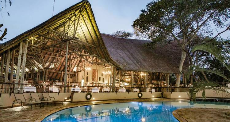 Lodge with a pool at sunset.